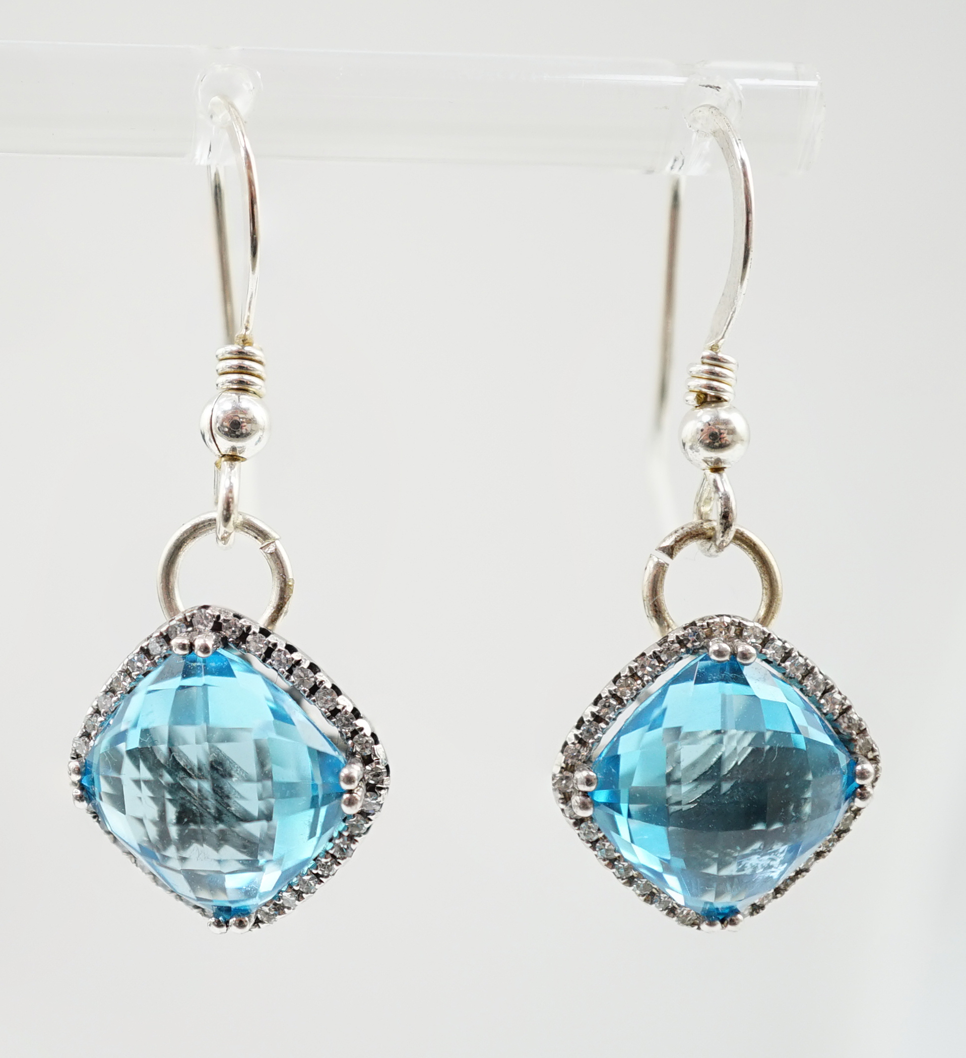 A pair of 375 white gold and facetted square cut blue topaz set drop earrings, with diamond chip set borders